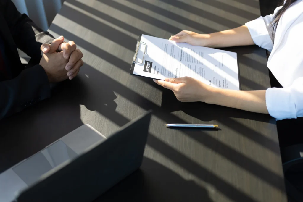 Employer reading resume of job interview candidate profile collection.