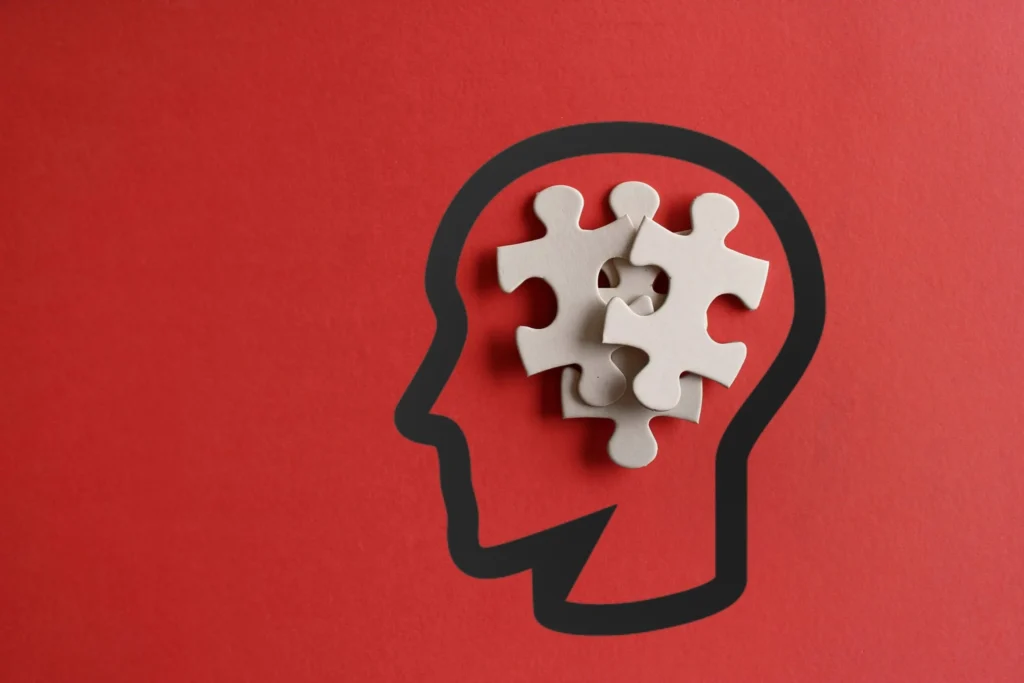 Scattered puzzles in human head on red background.